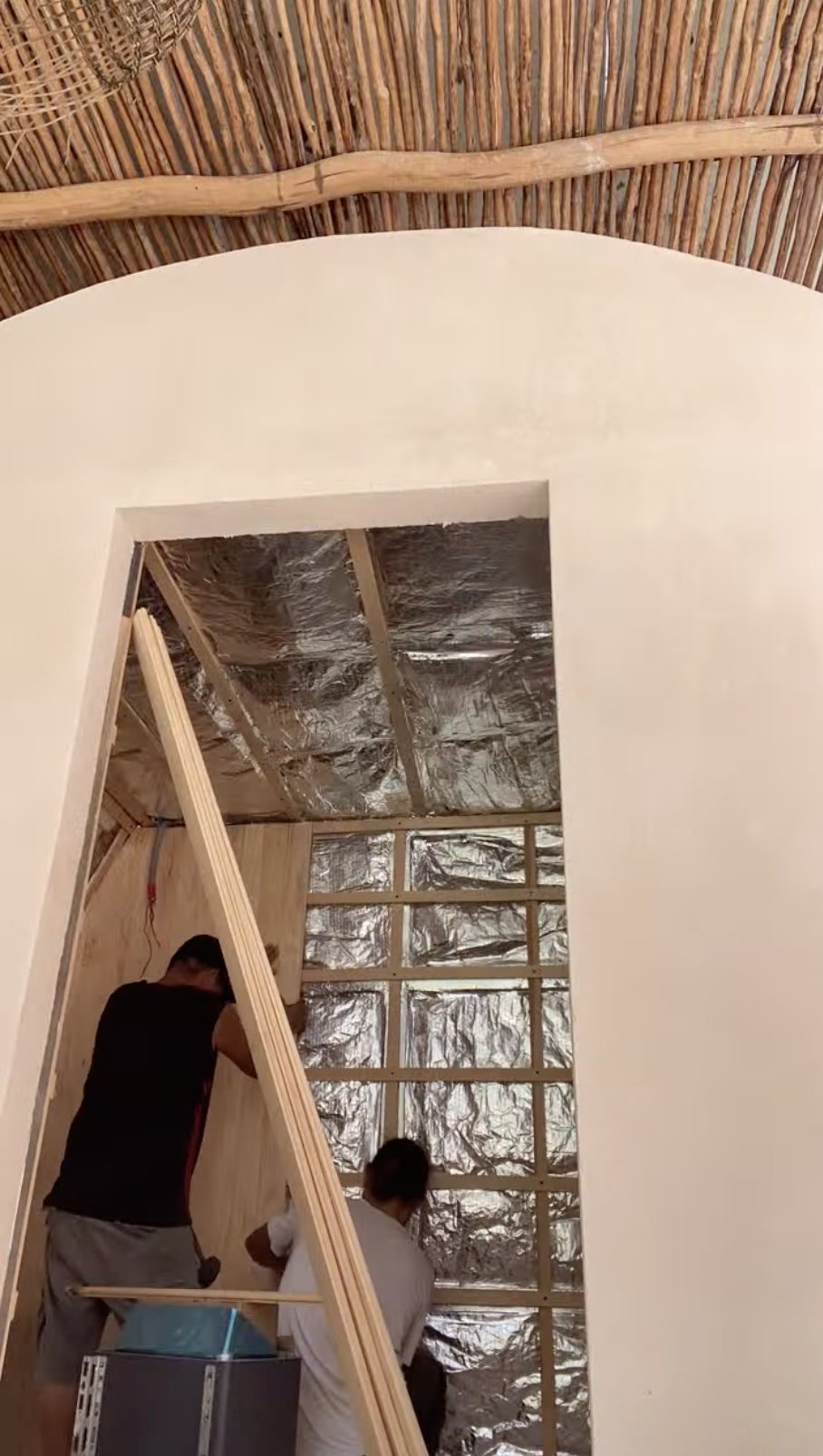 Insulation and vapour barrier being installed in a custom sauna